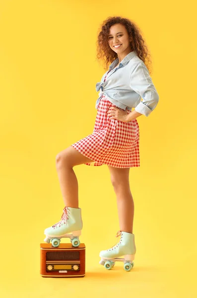 Beautiful young woman on roller skates and with retro radio receiver against color background — Stock Photo, Image