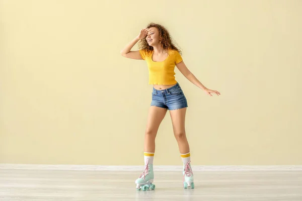 Belle jeune femme sur patins à roulettes contre le mur de couleur — Photo