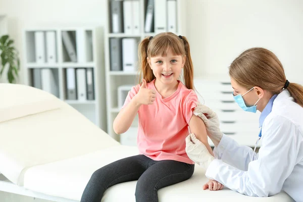 Doctor vaccinating little girl in clinic — Stock Photo, Image