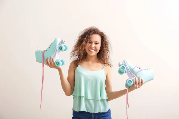 Beautiful young woman with roller skates on color background — Stock Photo, Image