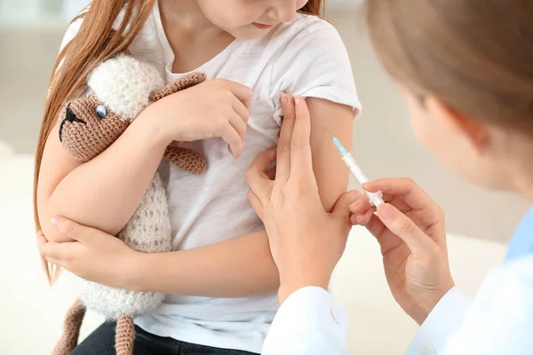 Doktor vaccinerar liten flicka i kliniken — Stockfoto