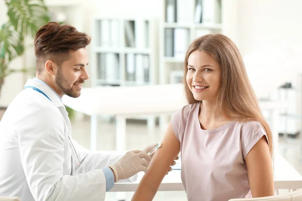 Doktor vaccinerande ung kvinna i kliniken — Stockfoto