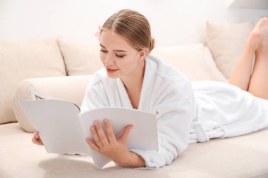 Spa salonunda dergi okuyan güzel genç kadın