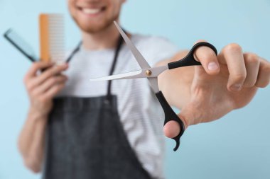 Renkli arka plan üzerinde makas ile genç erkek kuaför, closeup