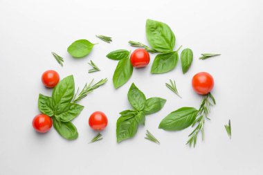 Beyaz arka planda taze yeşil fesleğen, domates ve biberiye