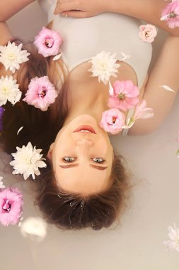 Spa salonunda çiçeklerle banyo yaptıran güzel genç kadın