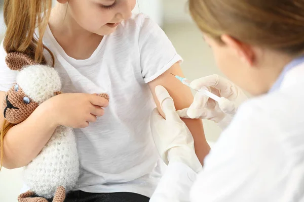 Doktor vaccinerar liten flicka i kliniken — Stockfoto
