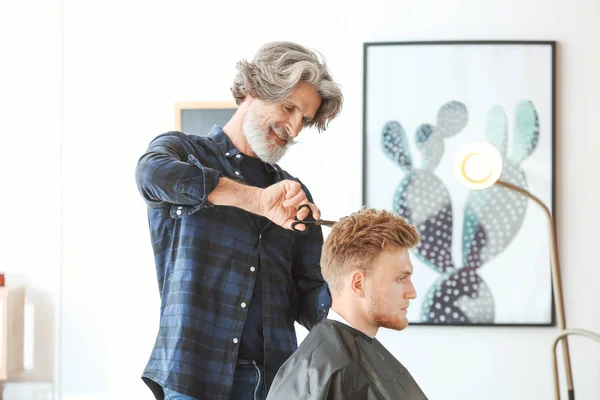 Coiffeur professionnel travaillant avec le client dans un salon de beauté — Photo