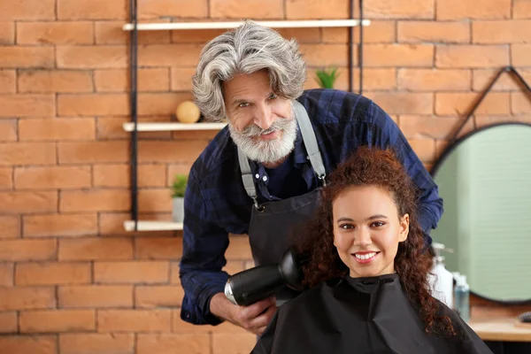 Професійний перукар, що працює з клієнтом в салоні краси — стокове фото