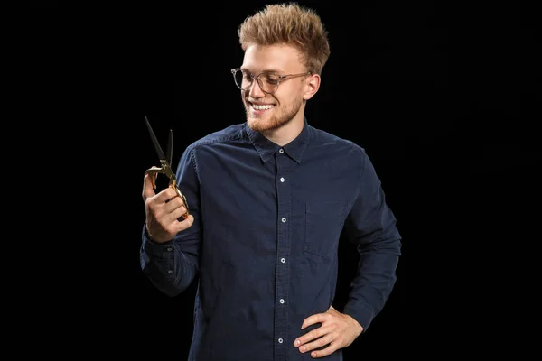 Young male hairdresser on dark background — Stock Photo, Image