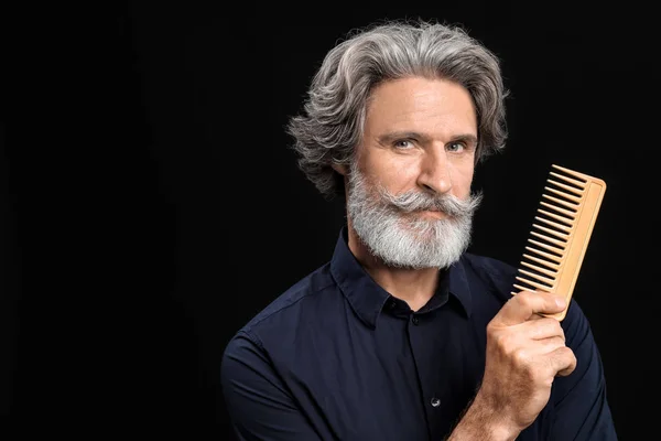 Mature male hairdresser on dark background — Stock Photo, Image