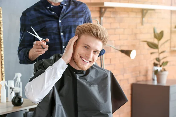 Young man with stylish haircut after treatment in beauty salon — Stock Photo, Image