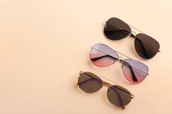 Различные стильные солнечные очки на цветном фоне — стоковое фото