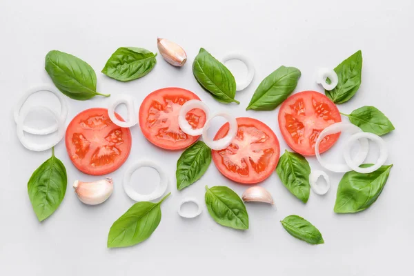 Albahaca fresca, tomate, cebolla y ajo sobre fondo claro — Foto de Stock