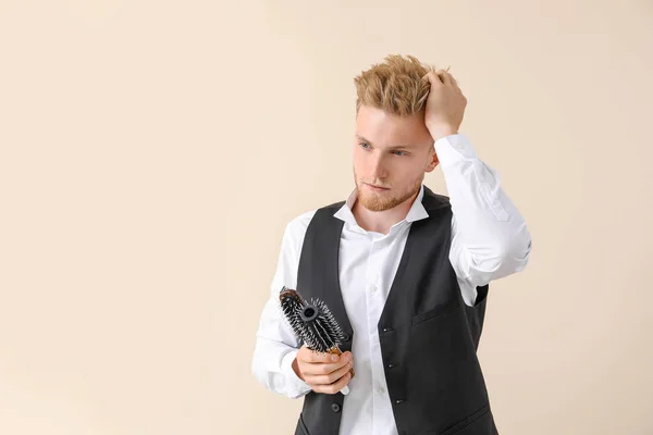 Young male hairdresser on light background — Stock Photo, Image