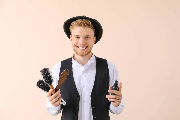 Young male hairdresser on light background — Stock Photo, Image