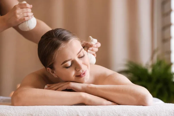 Beautiful young woman receiving massage in spa salon — Stock Photo, Image