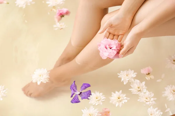 スパサロンで花と一緒にお風呂に入る美しい若い女性 — ストック写真