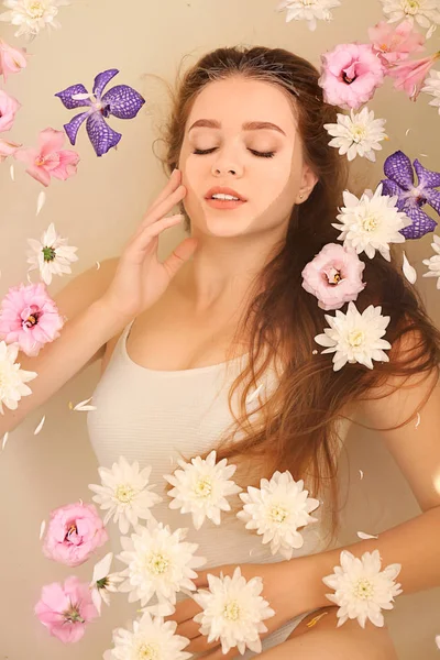 Hermosa mujer joven tomando baño con flores en el salón de spa —  Fotos de Stock