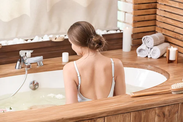 Красивая молодая женщина принимает ванну в спа-салоне — стоковое фото