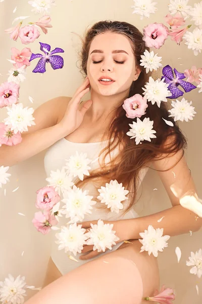 Vacker ung kvinna tar bad med blommor i Spa Salon — Stockfoto