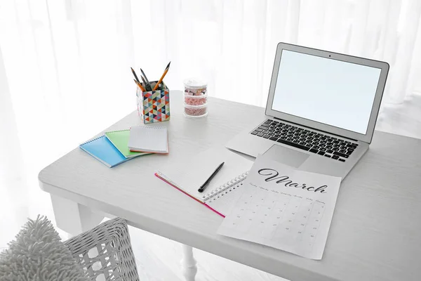 Сторінка календаря з ноутбуком та канцелярським приладдям на столі — стокове фото