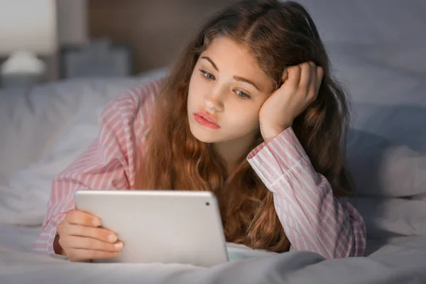 Teenage girl with tablet computer in bed at night — Stock Photo, Image