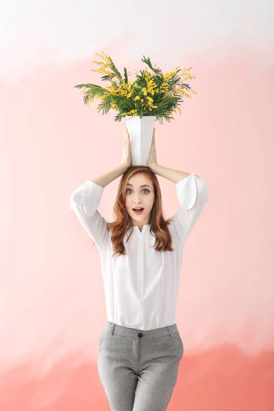 Beautiful young woman with bouquet of mimosa flowers on color background