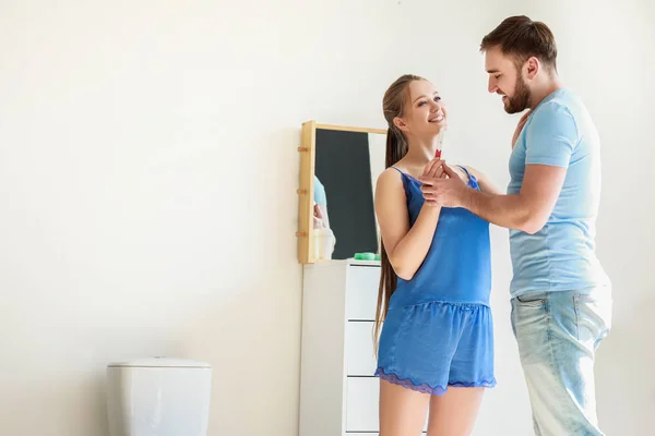 Happy couple with pregnancy test in restroom