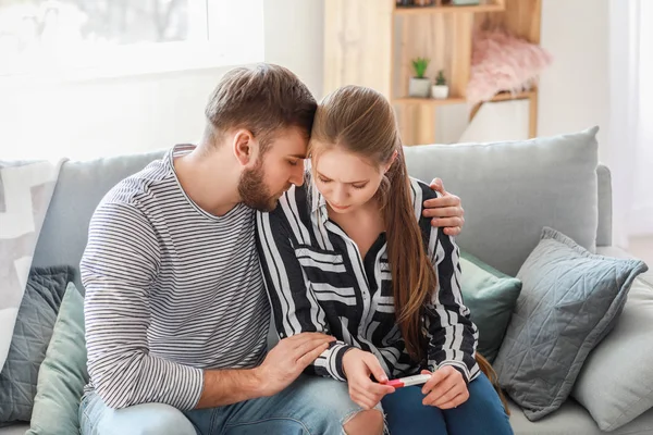 Sad couple with pregnancy test at home — Stock Photo, Image