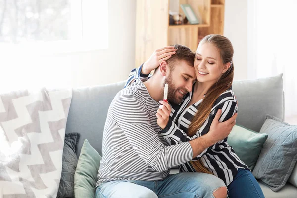 Pareja feliz con prueba de embarazo en casa — Foto de Stock