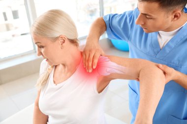 Rehabilitasyon merkezinde olgun hasta ile çalışan fizyoterapist