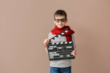 Renkli arka planda clapperboard ile küçük çocuk