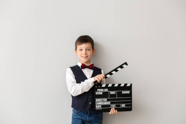 Beyaz arka planda clapperboard ile küçük çocuk