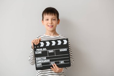 Beyaz arka planda clapperboard ile küçük çocuk
