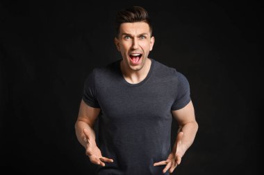 Karanlık arka planda agresif genç adam