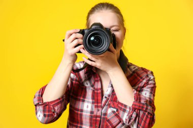 Renkli arka planda genç kadın fotoğrafçı