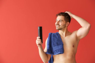 Renk arka planda şampuan ve havlu şişesi ile Yakışıklı adam