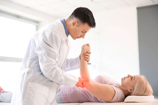 Physiotherapist working with mature patient in rehabilitation center — Stock Photo, Image