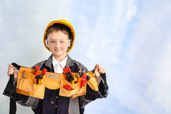 Lindo niño pequeño con herramientas cinturón en el fondo de color — Foto de Stock