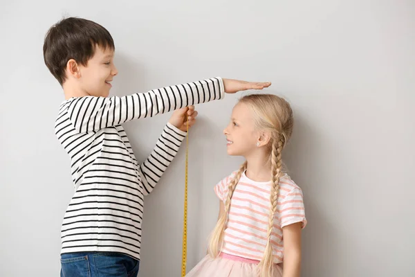 Schattige kleine kinderen meten hoogte in de buurt van de muur — Stockfoto