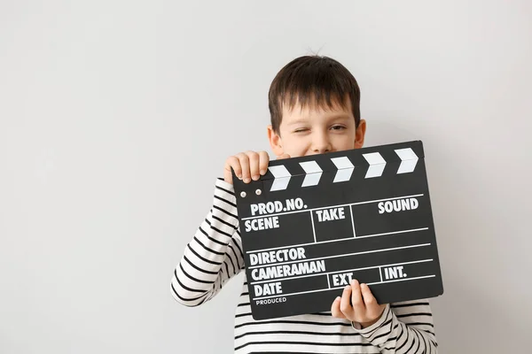 Liten pojke med klapperboard på vit bakgrund — Stockfoto