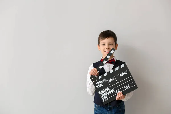 Liten pojke med klapperboard på vit bakgrund — Stockfoto