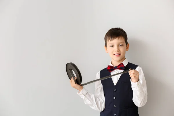 Kleiner Junge mit Filmstreifen auf weißem Hintergrund — Stockfoto