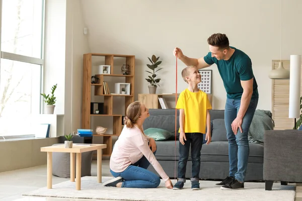 Parents measuring height of their son at home — Stock Photo, Image