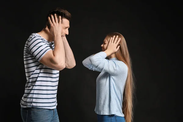 Jeune couple querelleur sur fond sombre — Photo