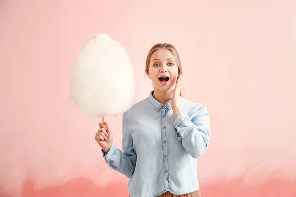 色の背景に綿菓子を持つ驚いた女性 — ストック写真