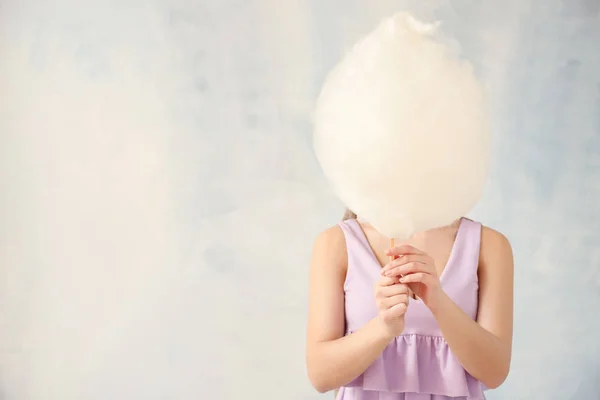 Beautiful woman with cotton candy on light background — Stock Photo, Image