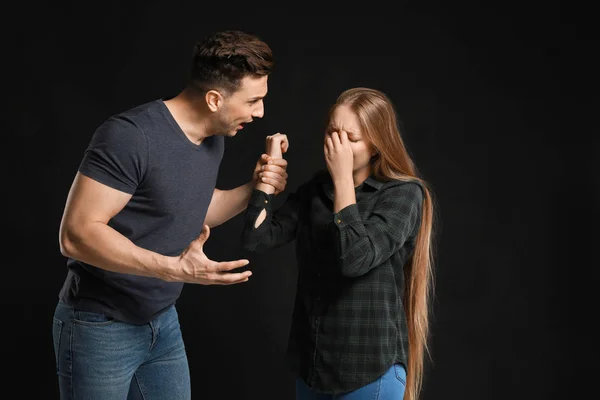 Young quarrelling couple on dark background