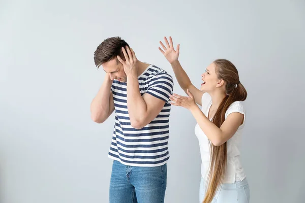 Giovane coppia litigando su sfondo chiaro — Foto Stock